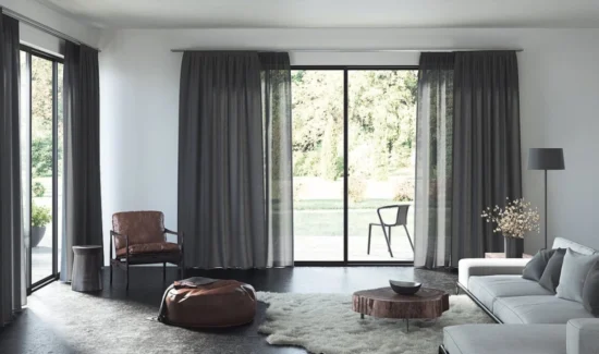 Wohnzimmer mit bodentiefen Fenstern und dunkelgrauen Vorhängen